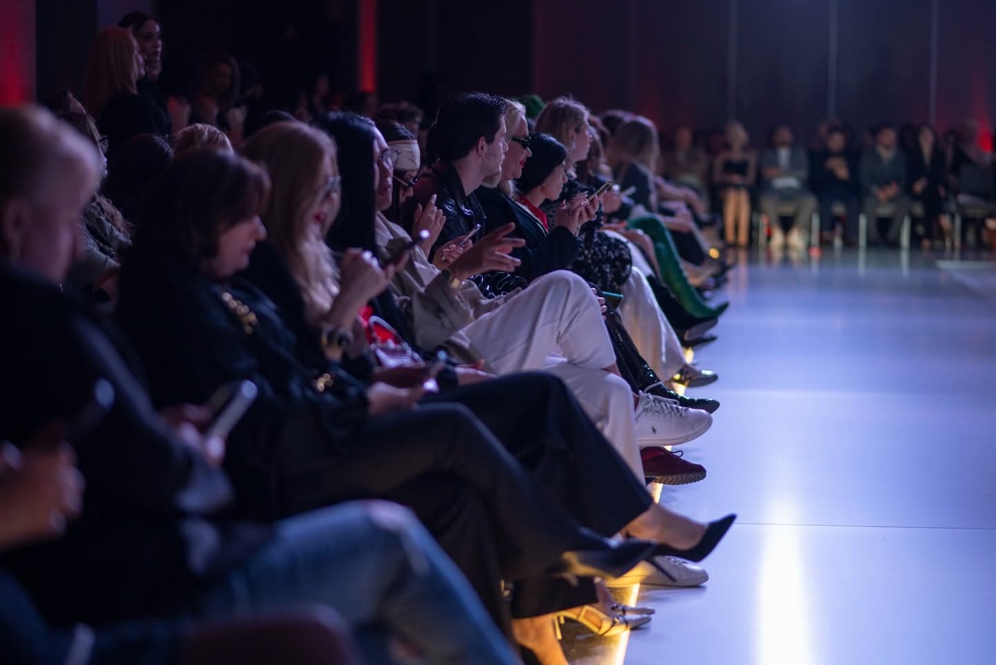 Audience along the gold-lit runway